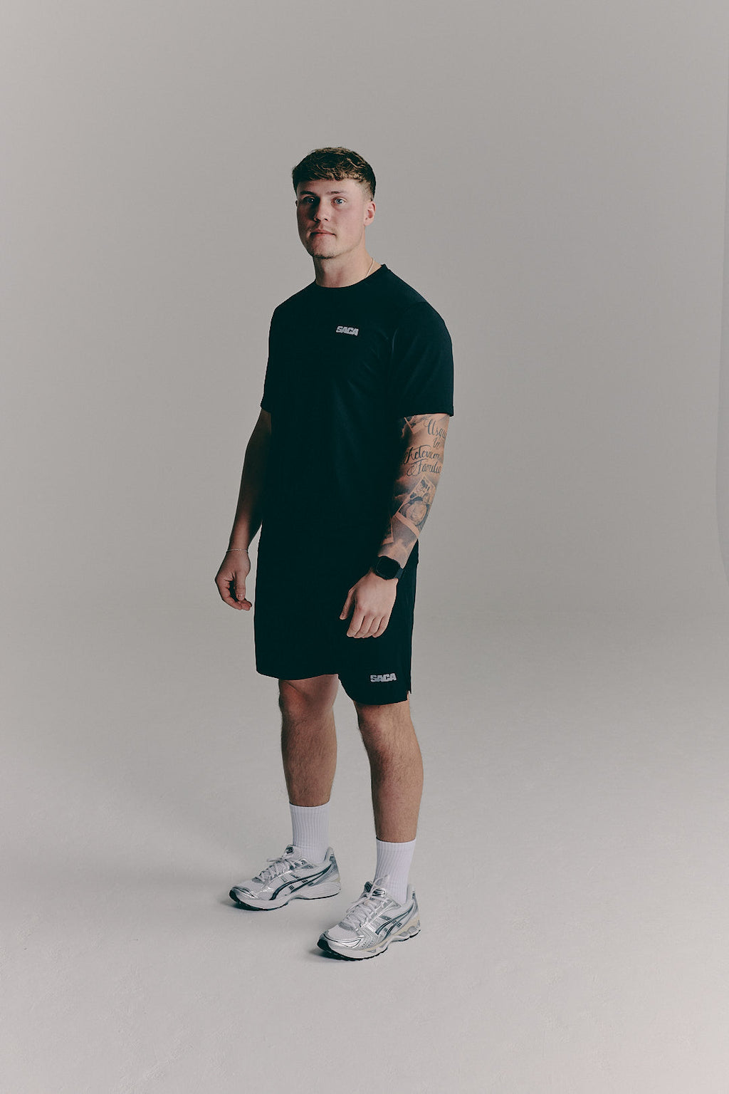 SACA Essential Tee in black — back view worn by model