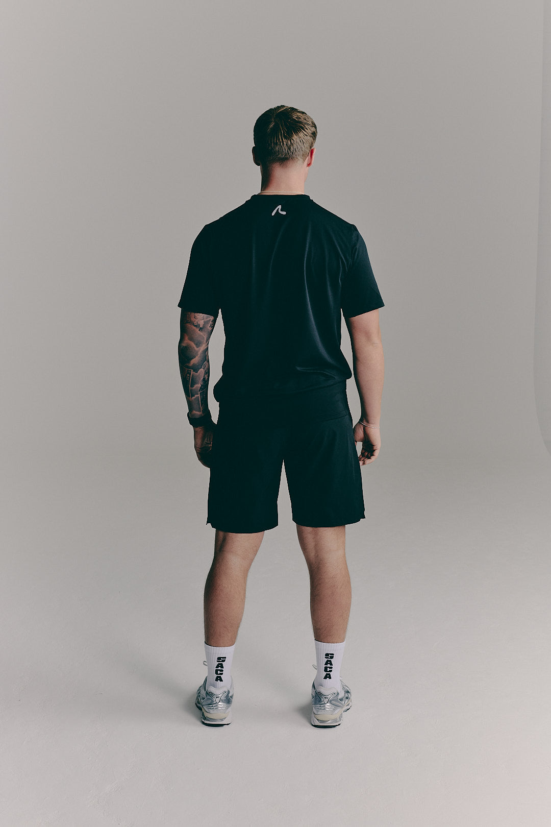 SACA Essential Tee in black — side view worn by model