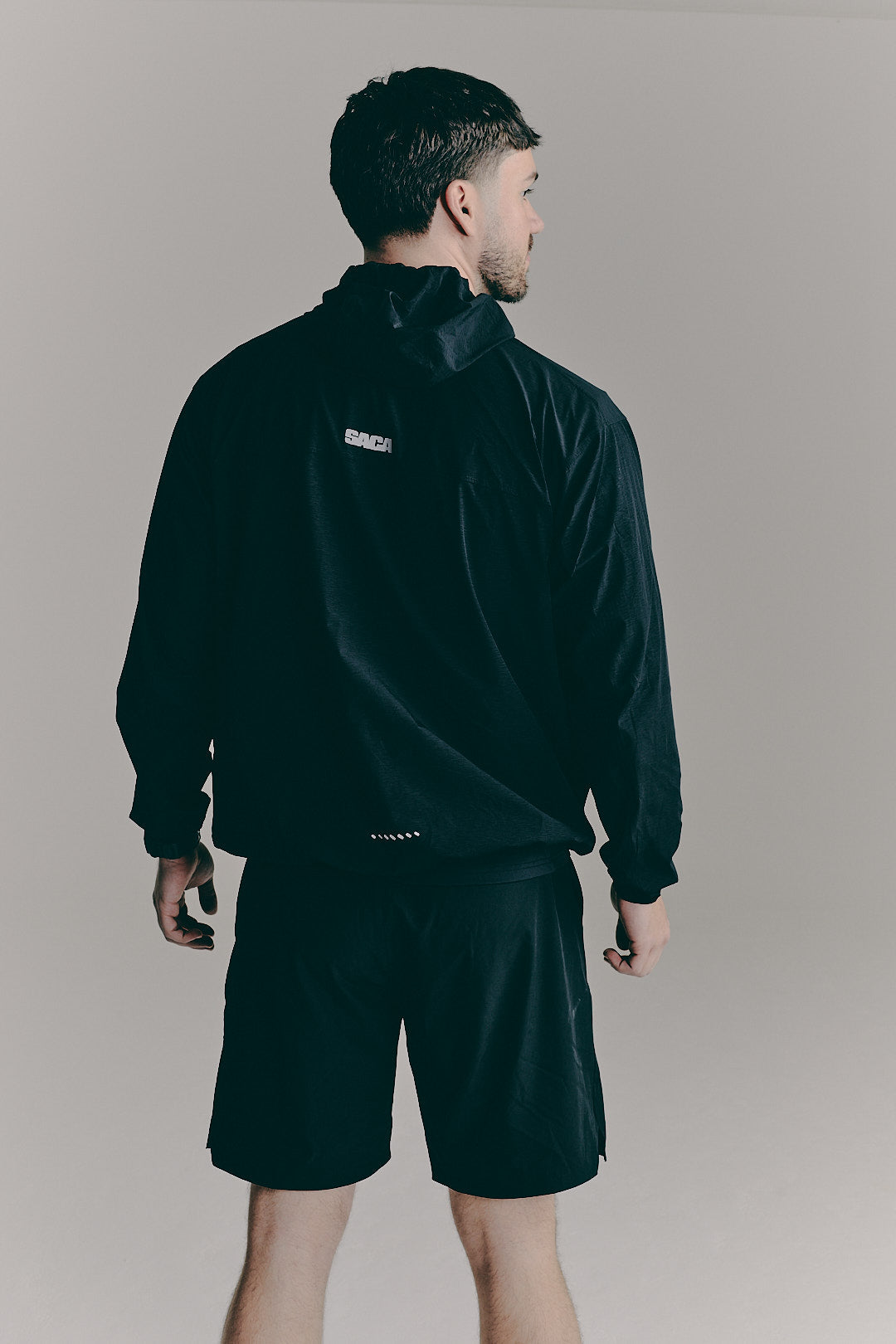 SACA Flux Windbreaker in black — back view worn by model